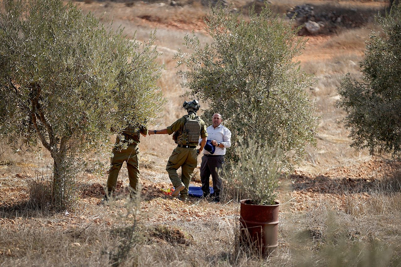 Soldados israelíes dispersan a agricultores palestinos y activistas de izquierda, impidiéndoles recoger aceitunas durante la temporada de cosecha anual, en la aldea de Qusra, Cisjordania ocupada, el 29 de octubre de 2024. (Flash90)