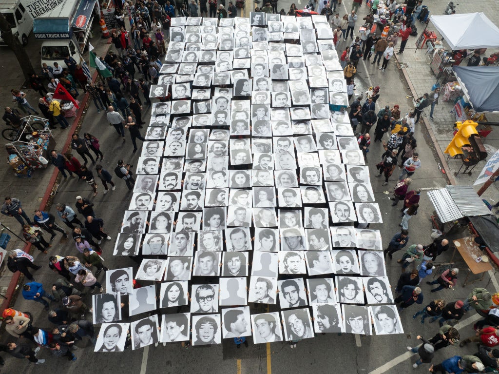 Vista area de personas participando en una intervención del grupo Imgenes del Silencio con retratos de personas...